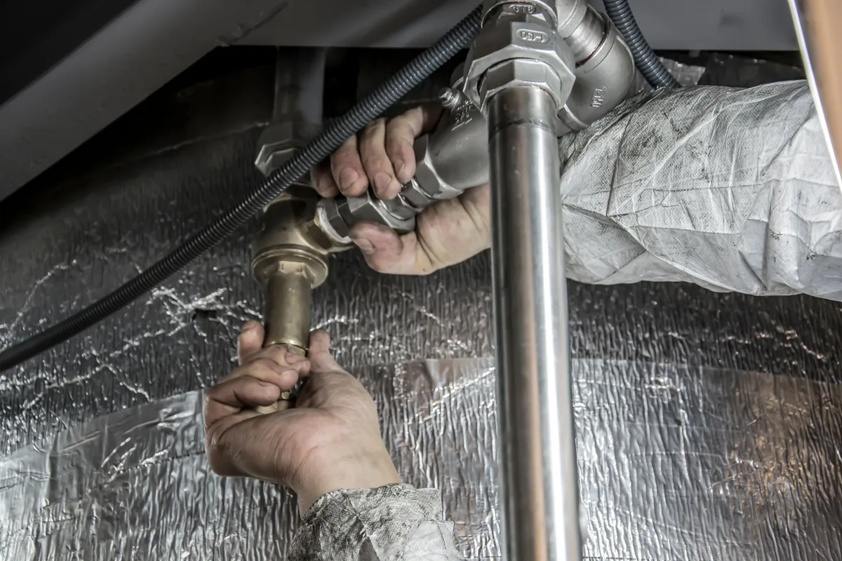 Gas union and isolation valve being fitted by hand during a gas geyser installation