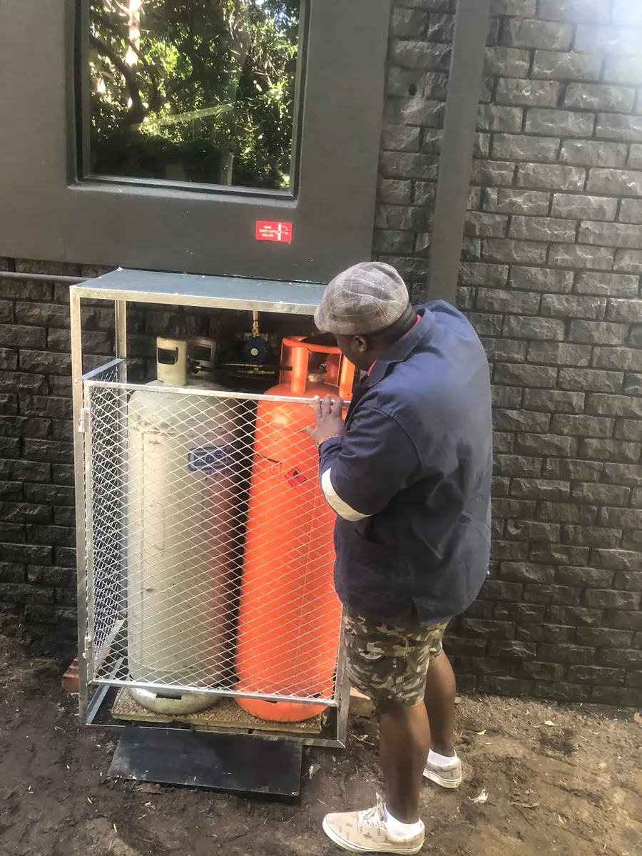 Two-cylinder gas bank installed in a galvanised cage by Red Flame Gas Supplier, with the auto-changeover regulator fitted